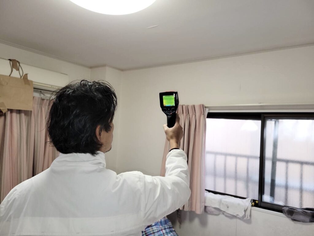 株式会社由健/株式会社健装の代表取締役の由野和隆さんが、雨漏りの調査をしている写真・その１